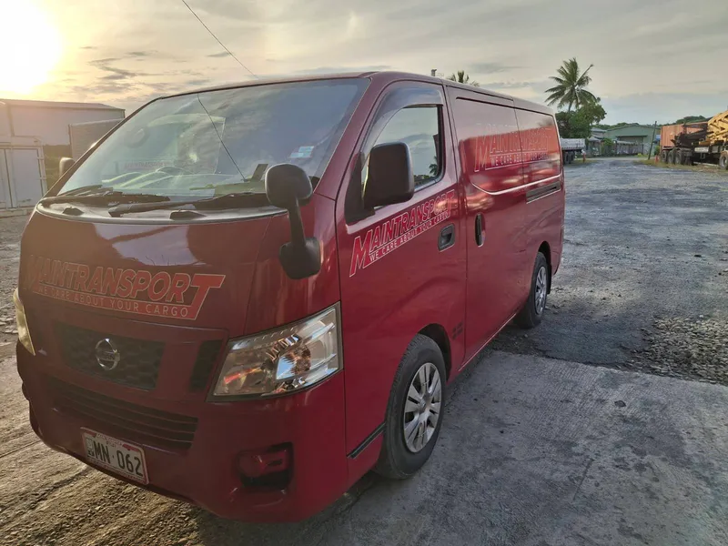 Red Main Transport Nissan van parked at the Suva depot at dusk
